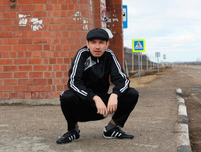 Squatting slav in a tracksuit.